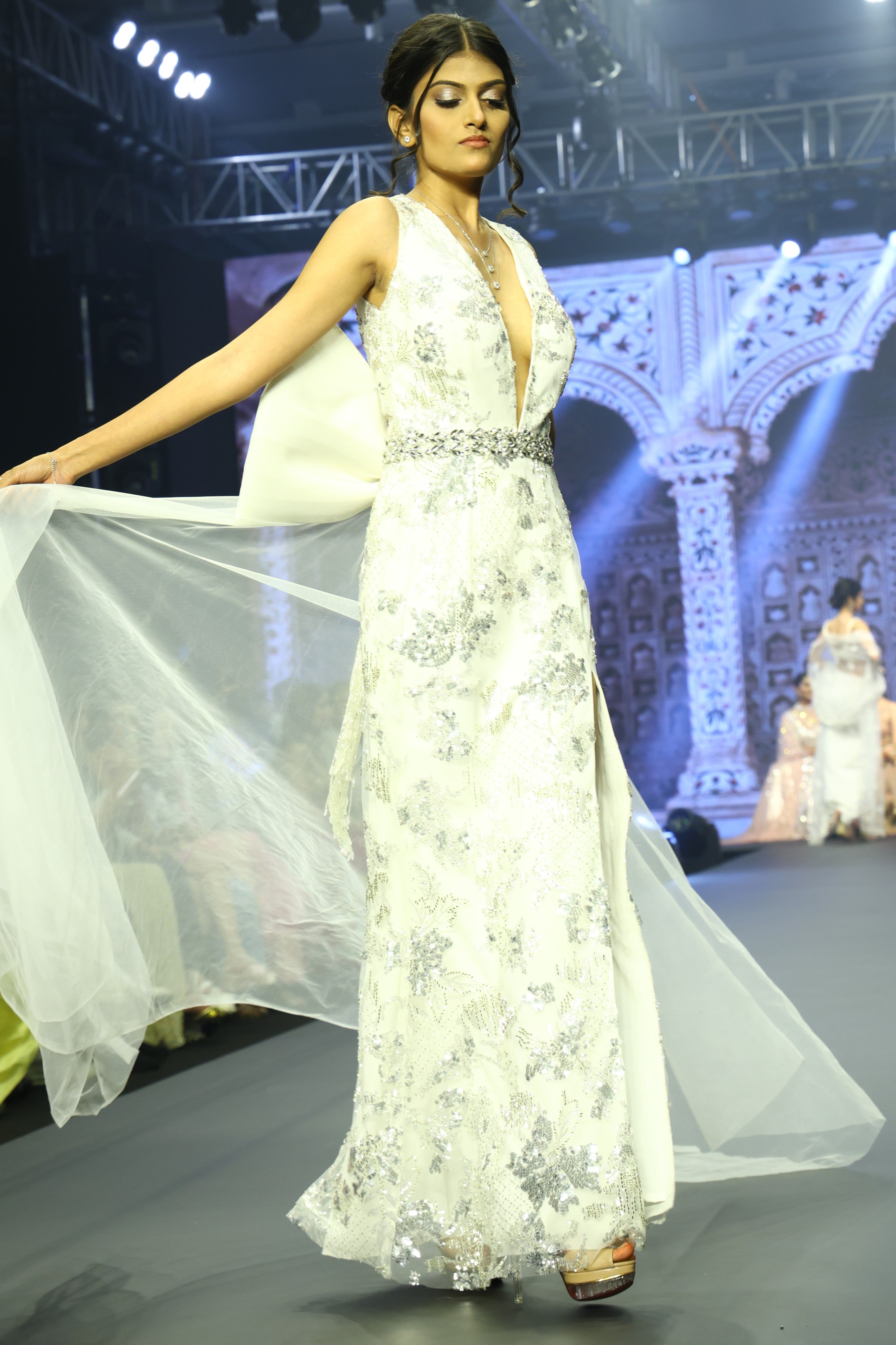 White sequin gown with bow trail at back