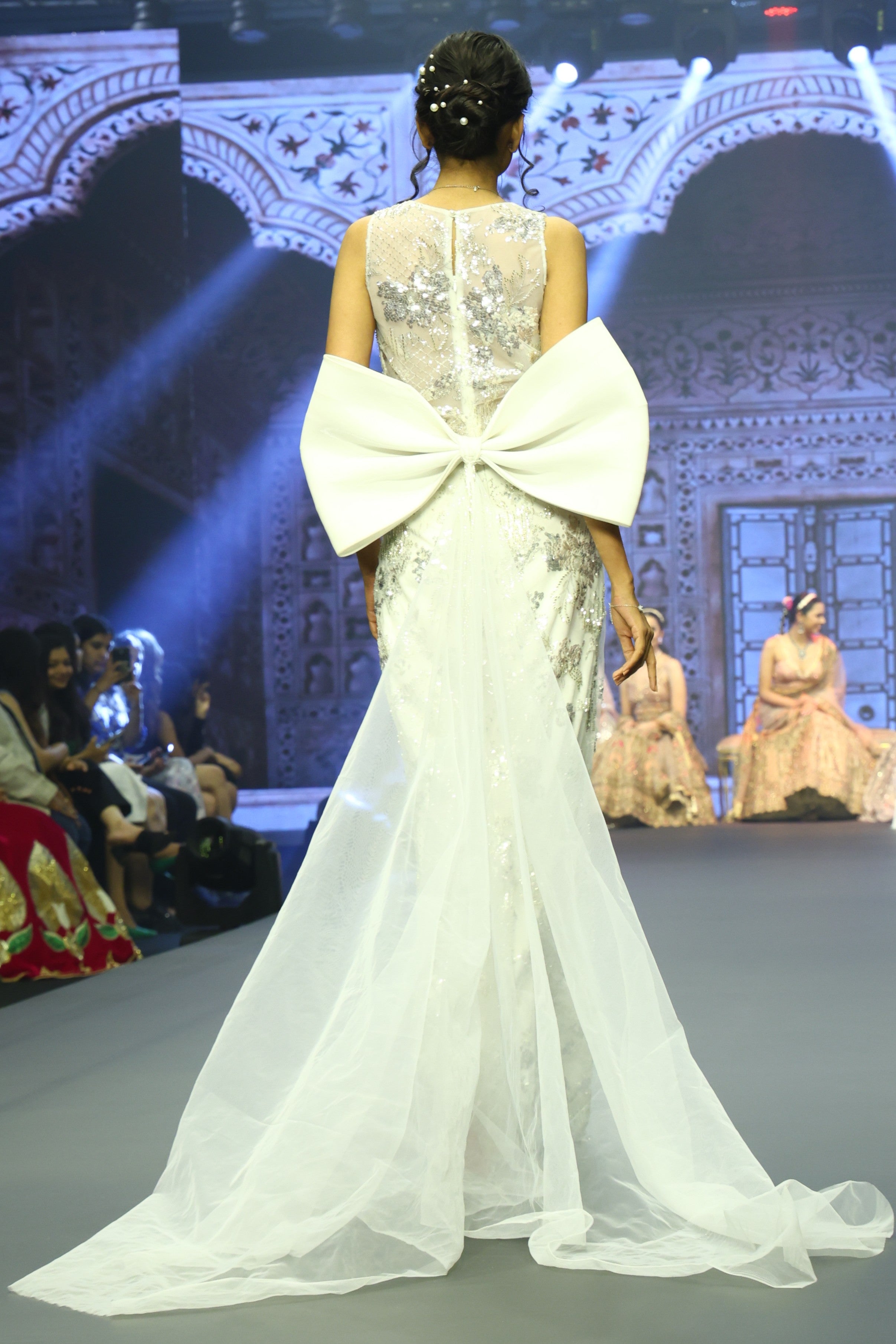 White sequin gown with bow trail at back